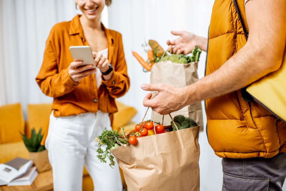 Mulher recebendo compras por delivery em casa